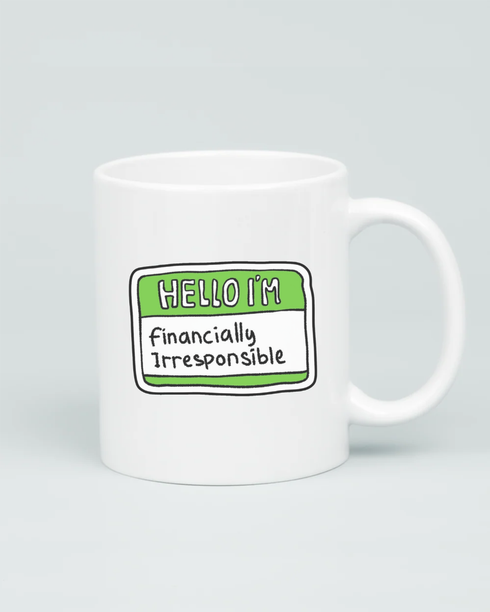A premium white ceramic mug featuring a green and white "Hello I'm" name tag sticker design with the handwritten words "Financially Irresponsible" in the center.