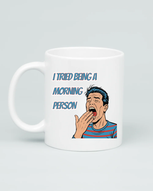 Aviza mug featuring a retro comic-style illustration of a man yawning with the text 'I TRIED BEING A MORNING PERSON' in a bold vintage font