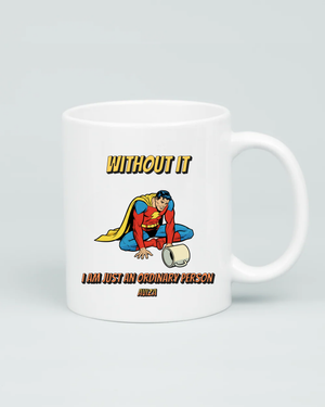 Back view of Aviza mug showing a defeated-looking superhero on the floor with an empty mug and text reading 'WITHOUT IT I AM JUST AN ORDINARY PERSON'.