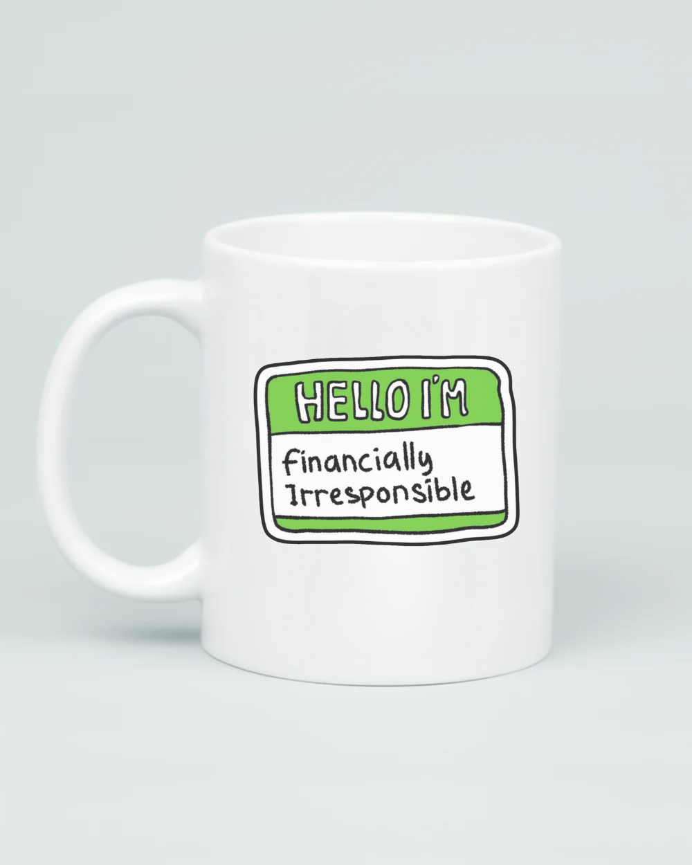 A premium white ceramic mug featuring a green and white "Hello I'm" name tag sticker design with the handwritten words "Financially Irresponsible" in the center.