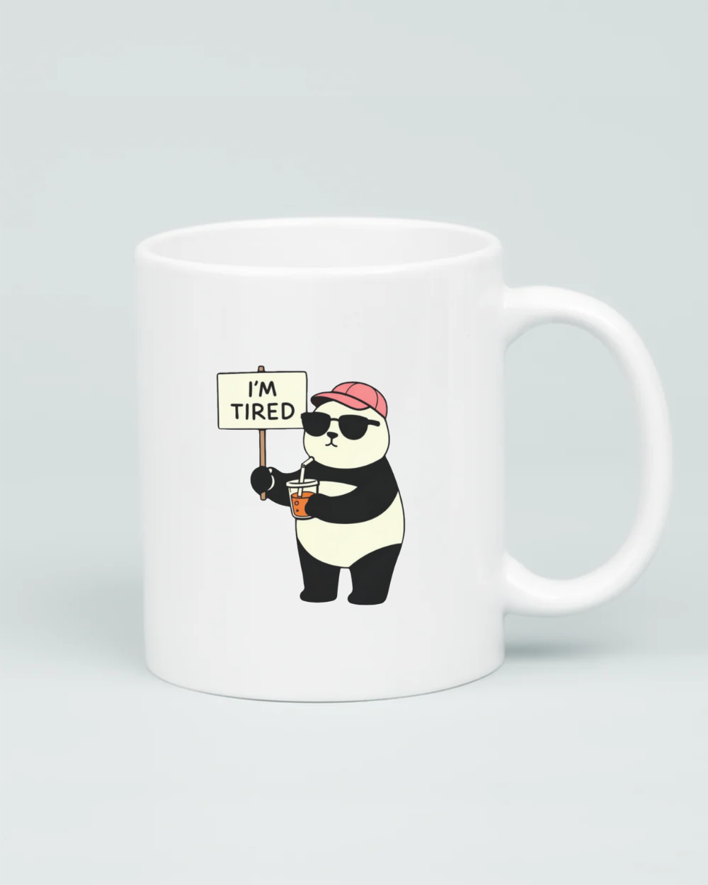 White coffee mug featuring a cartoon panda wearing sunglasses and a pink hat, holding a coffee and an 'I'm Tired' sign, on a clean grey background.