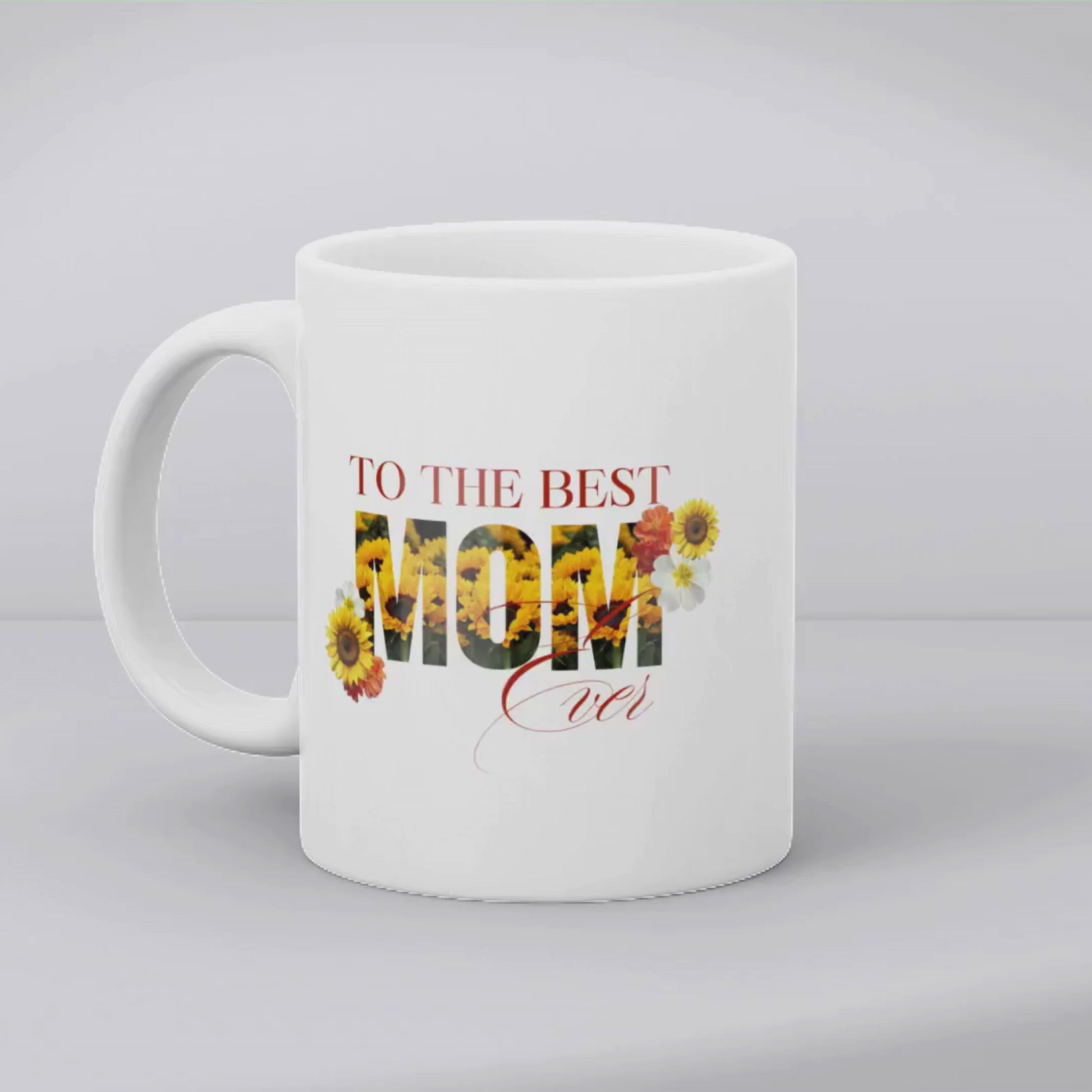 Aviza Best Mom Ever Sunflower Mug featuring the word 'MOM' filled with vibrant yellow sunflowers and elegant script on a white ceramic base.